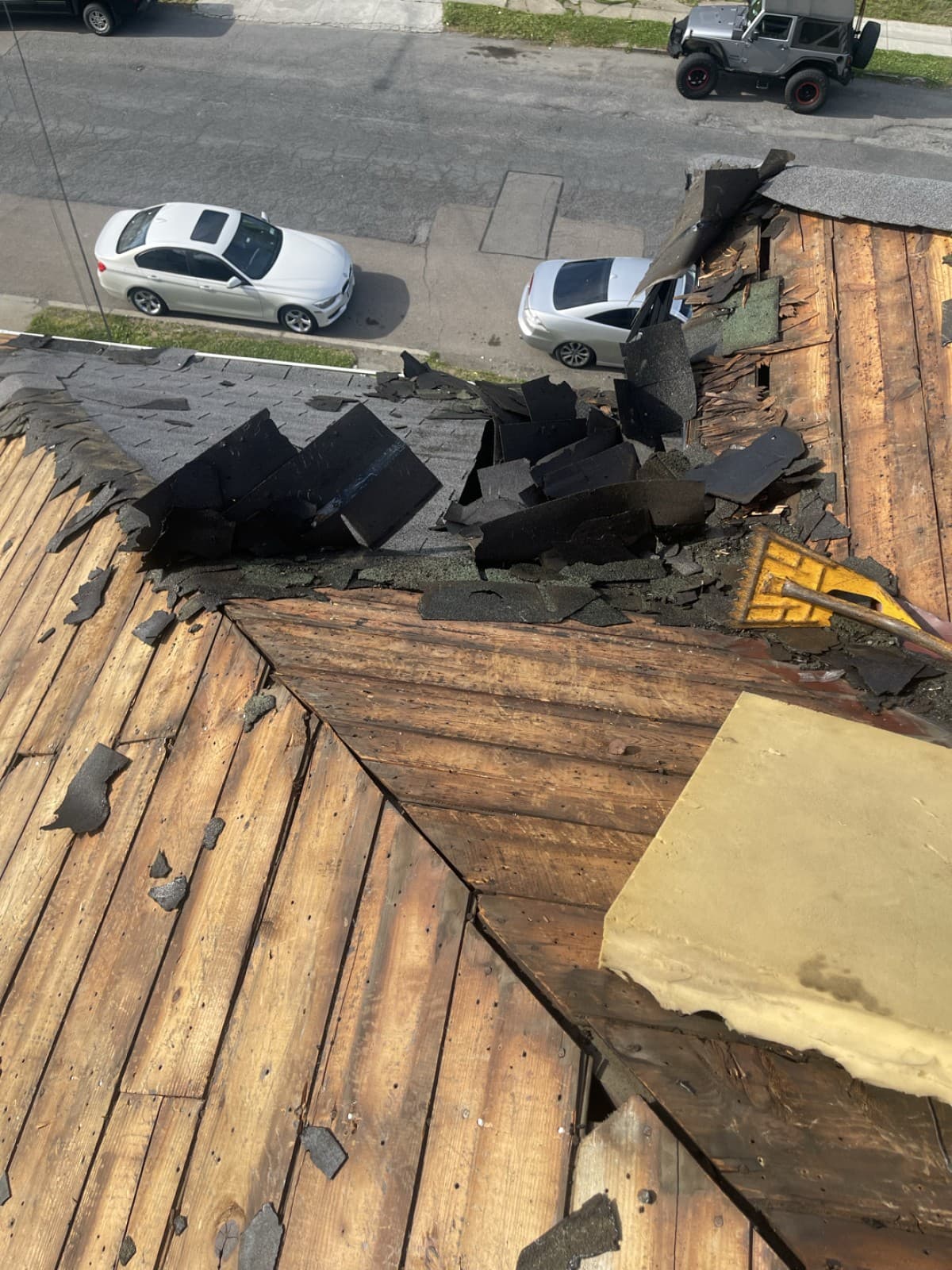 Old shingles and exposed wood boards in a roof valley during removal