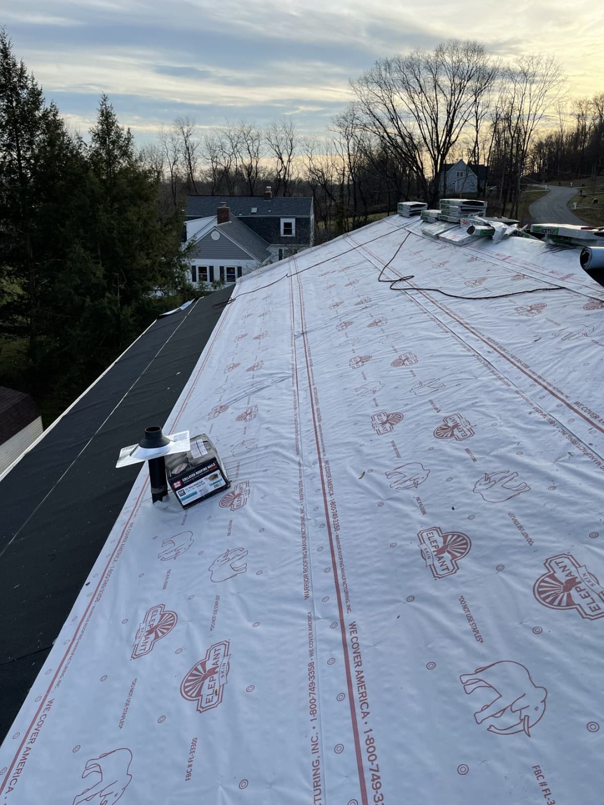Sloped roof covered with white underlayment before shingle installation