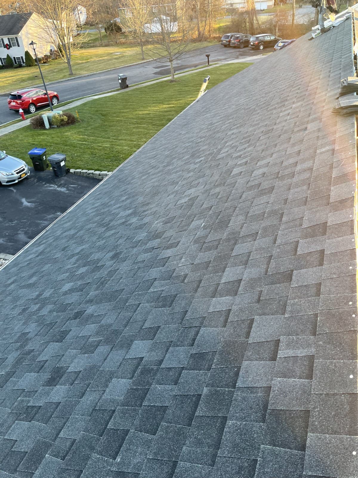 Gray shingles on a sloped roof overlooking a residential street