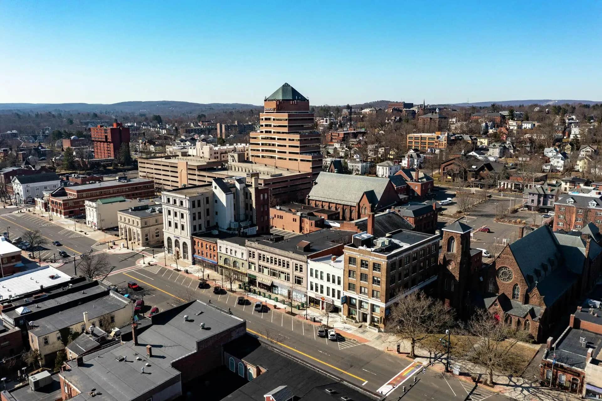 Aerial view of downtown buildings and streets with a stepped-roof tower
