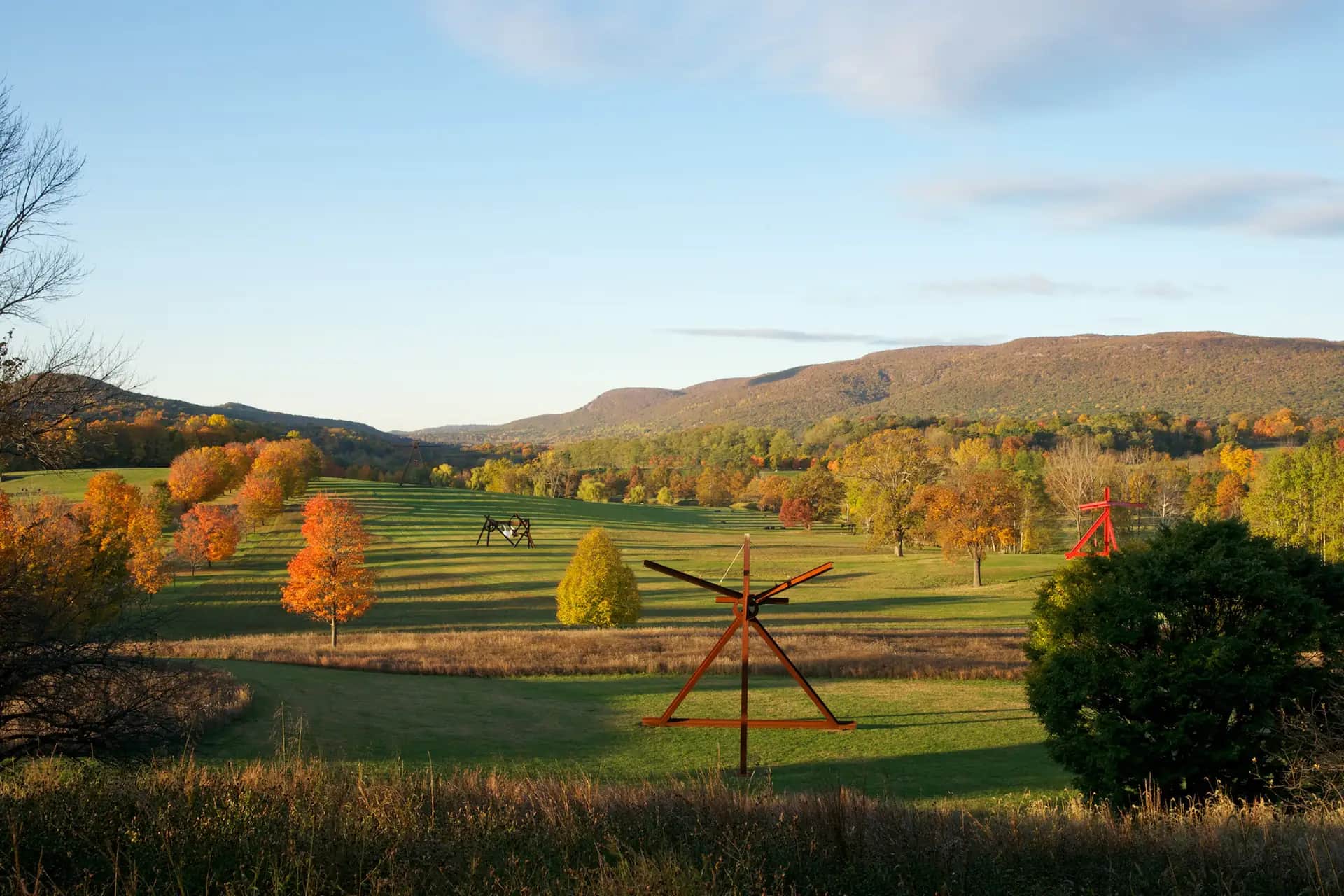 Outdoor sculptures in rolling fields surrounded by autumn trees