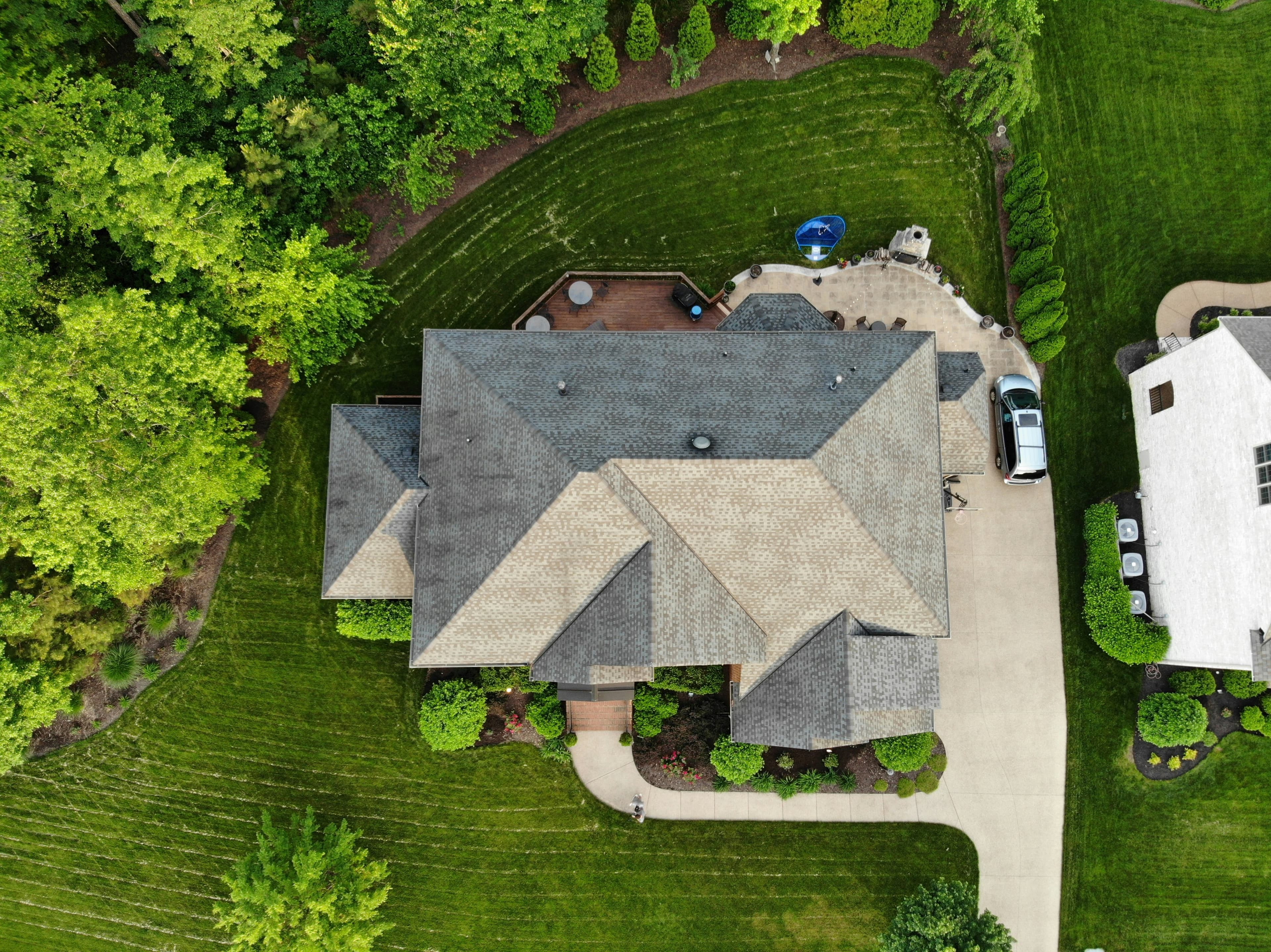 Overhead view of a gray shingle roof, roof valleys, and adjoining lawn